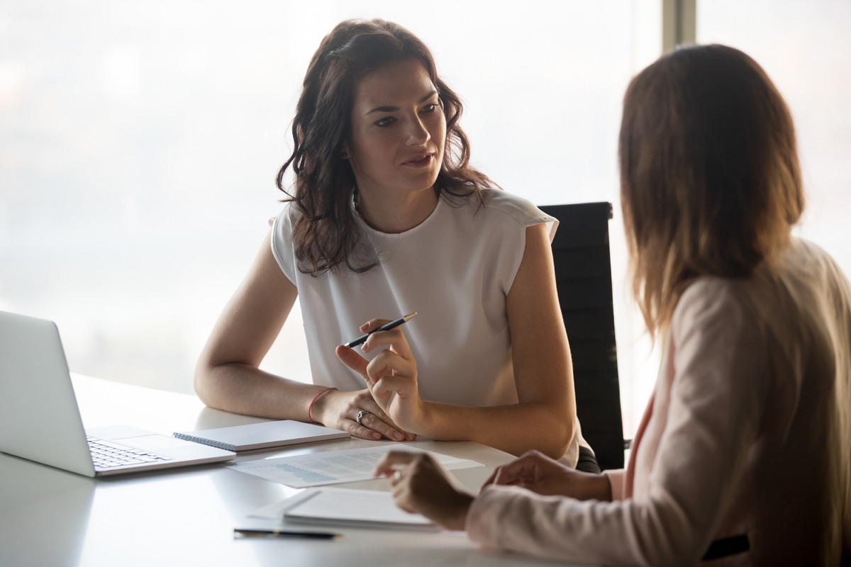 A woman speaking with a client at a desk